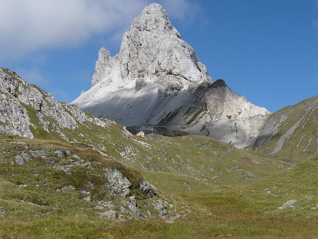 Eine Berghütte vor einem markanten Berggipfel